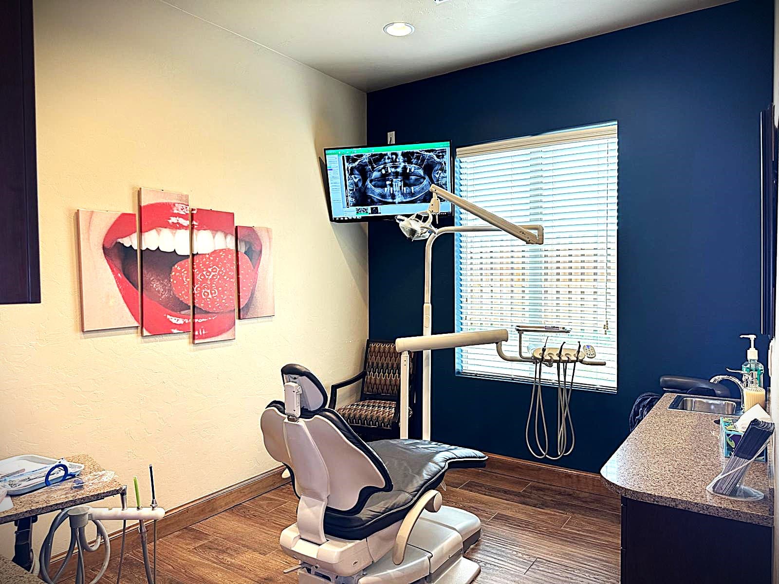 Operatory at Dental Art Center: patient chair and delivery unit, a panoramic radiograph of an implant case on the wall screen
